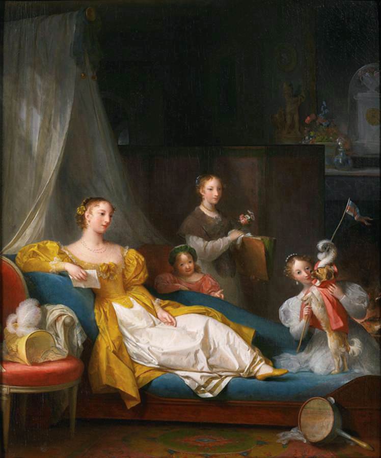 Une famille dans un intérieur jouant avec un chien