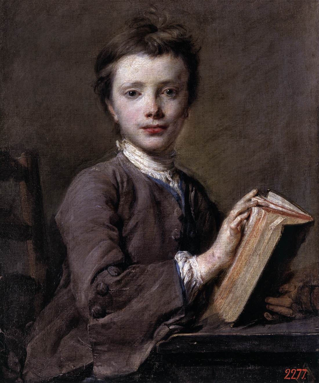 Portrait d'un garçon tenant un livre