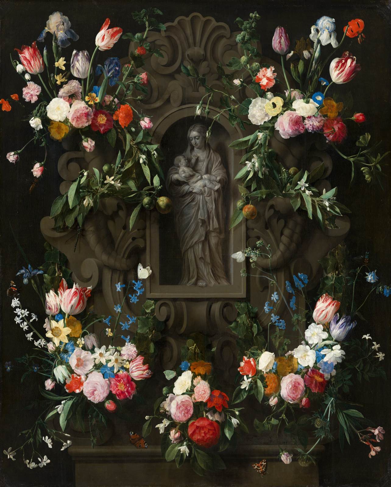 Guirlande de fleurs entourant une sculpture de la Vierge